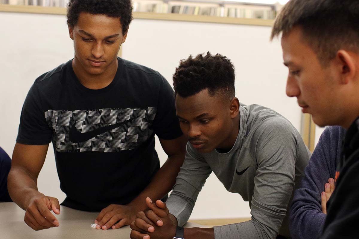 Members of the 2022 Wabash Liberal Arts Immersion Program, Raymond Arebalo ’25, Olivier Tuyishime ’25, and Grayson Dunn ’25, discuss a point during a program module on game development.