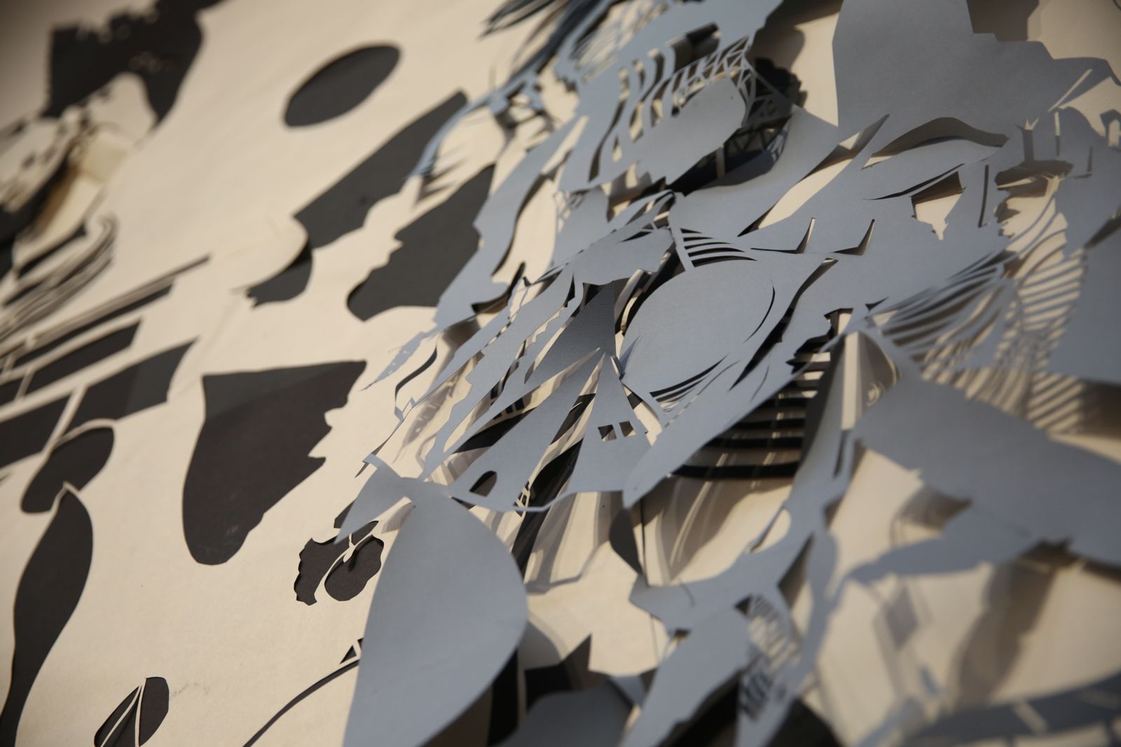 Blue and black paper cut into interesting shapes and mounted on a white wall