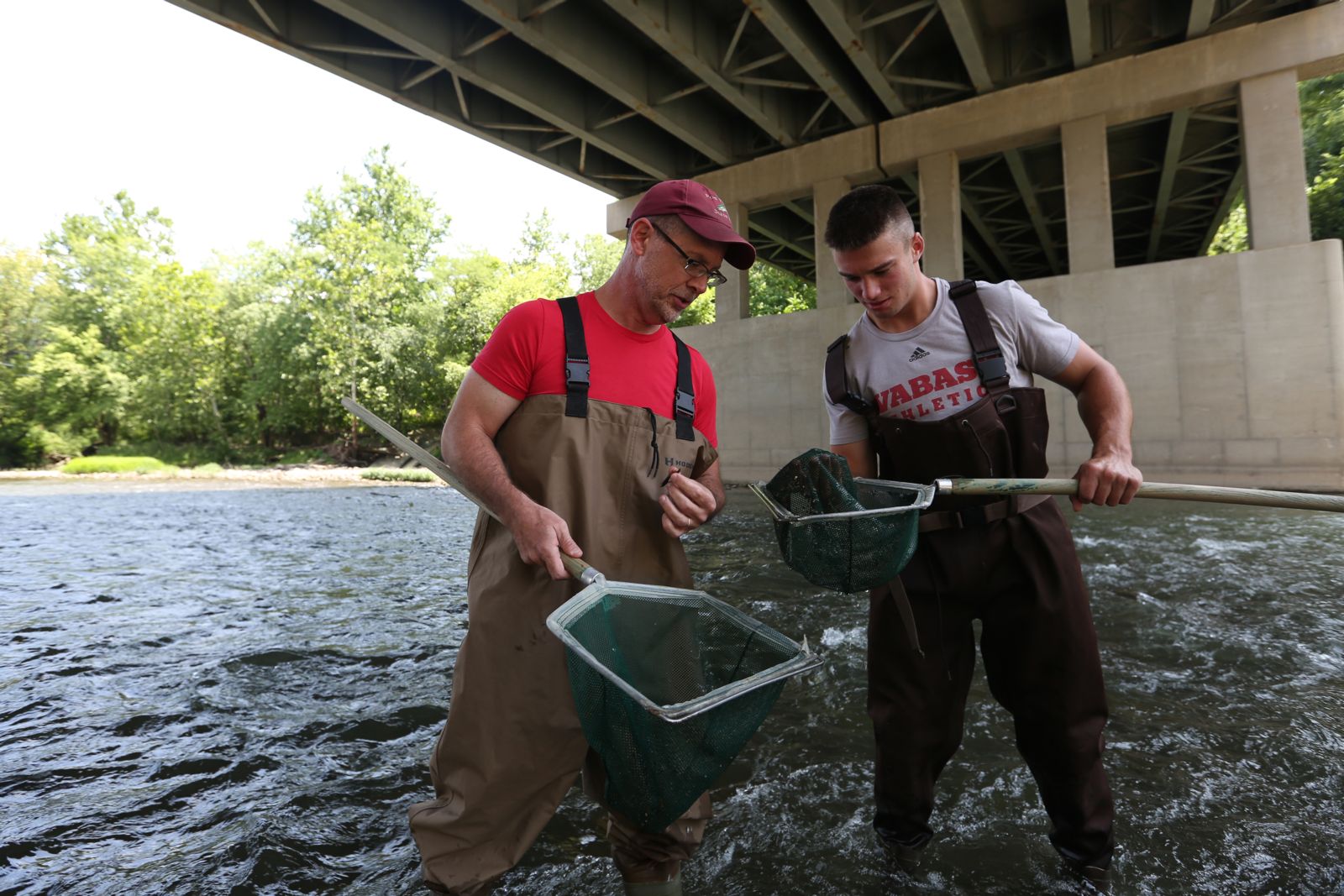 Dr. Eric Wetzel reviews environmental impacts on Sugar Creek with a student.