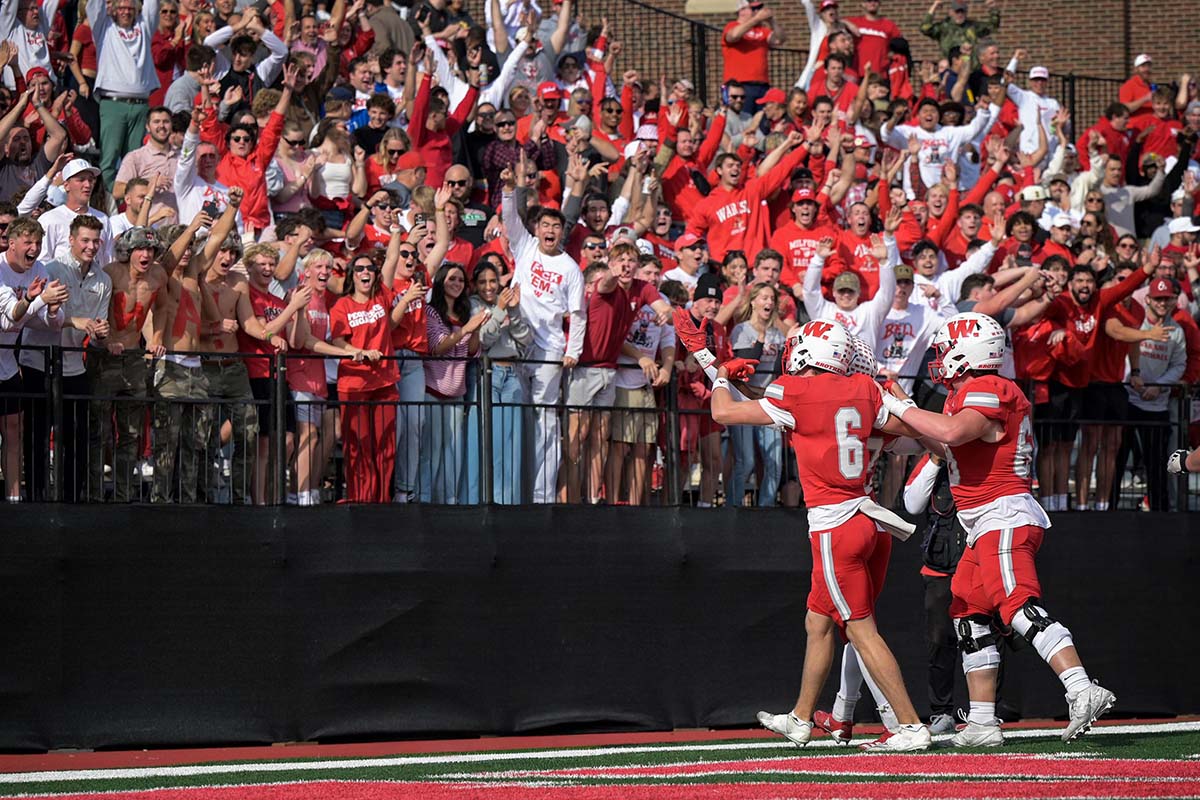 football players on a field, rallying the fans