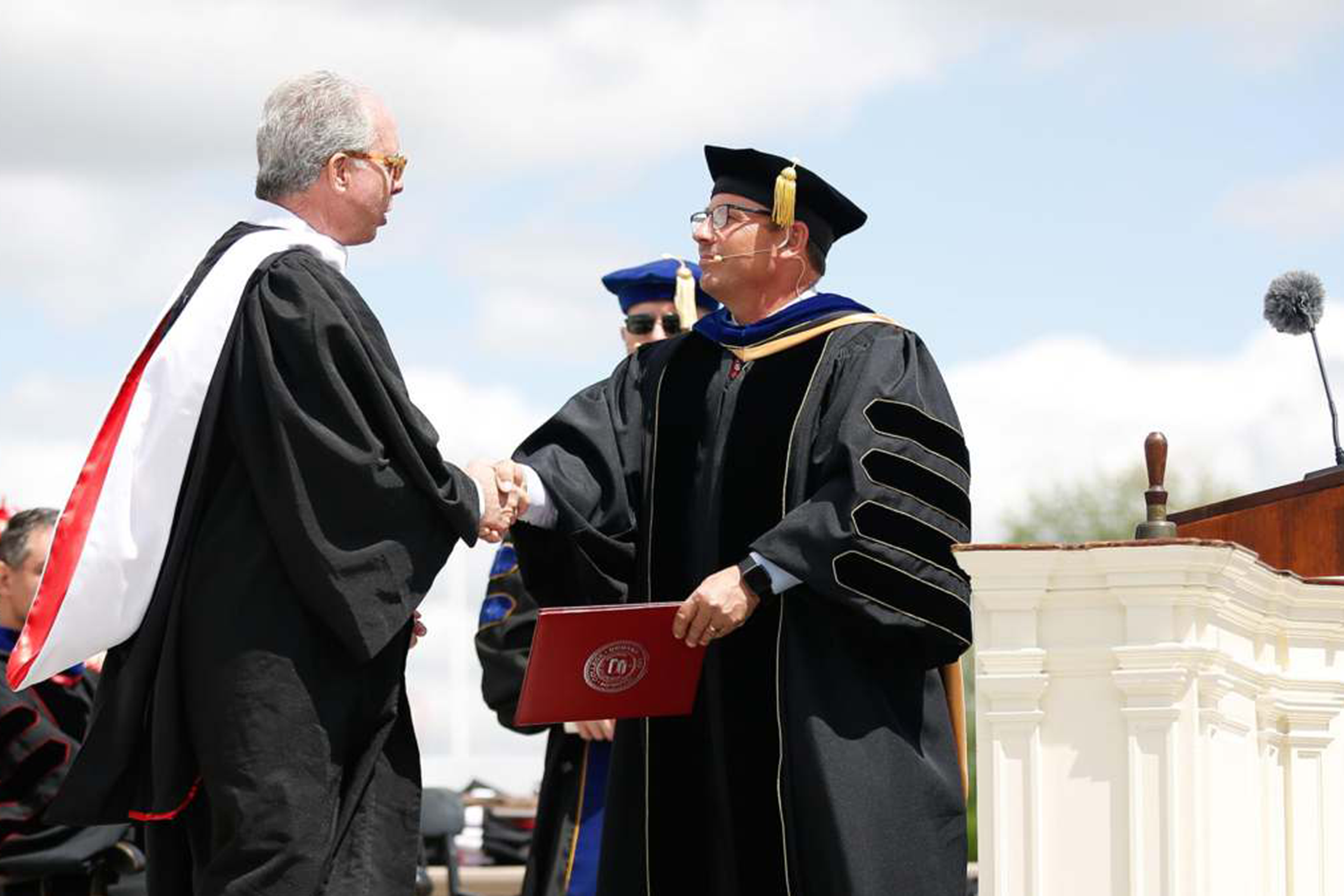 President Scott Feller presents Kevin G. Clifford '77 with an honorary degree.