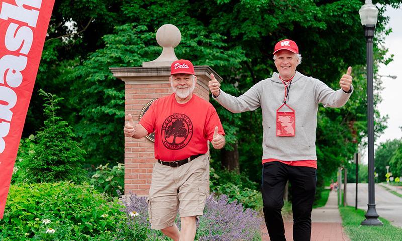 Alumni give thumbs up as they participate in the fun run and walk around campus.