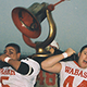 two men in football uniforms holding a trophy