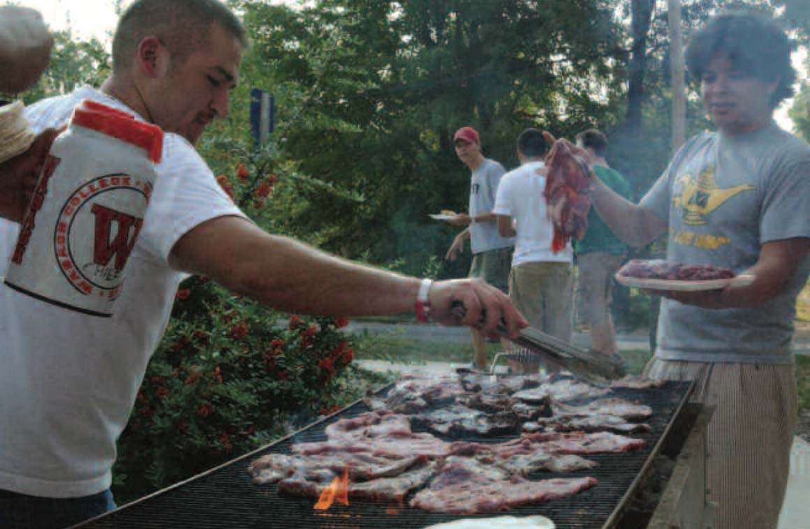 a man cooking meat on a grill