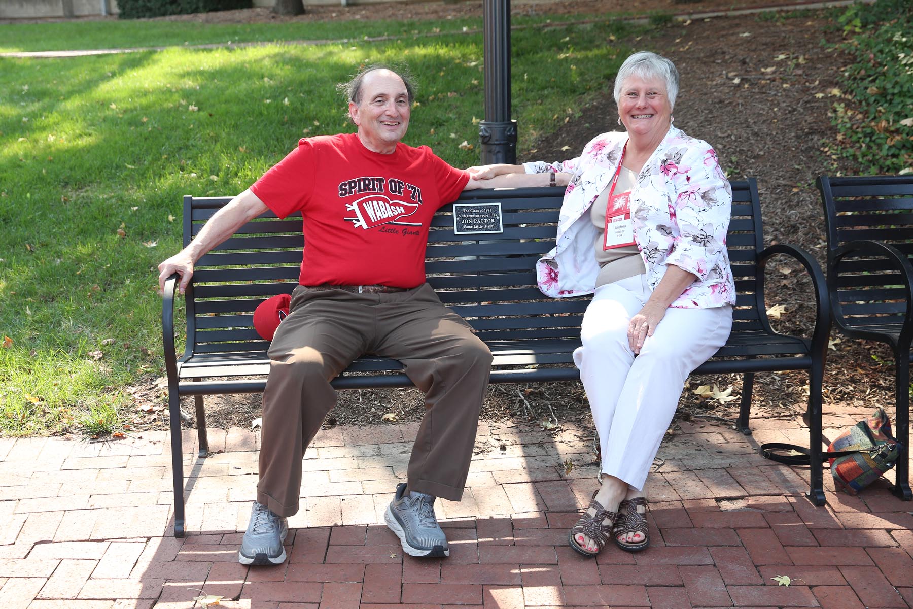 Jon and Andrea Pactor sit outside of the Allen Center on the bench dedicated to Jon by the Class of 1971. 