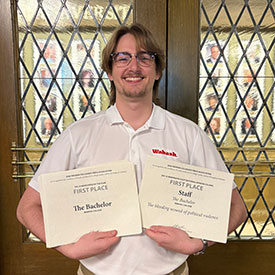 Nathan Ellenberger poses with the top DIII publication award and the first-place staff editorial award.