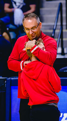 Head Coach Kyle Brumett hugs his son, Monte, prior to Friday's game.