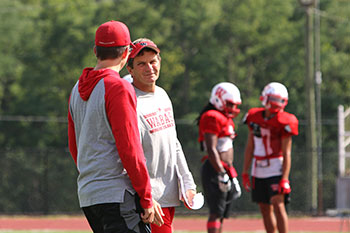 CJ, left, and Jeff Ramsey talk during football practice.