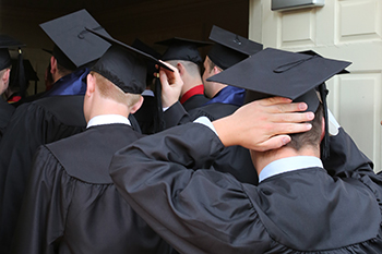 Graduates adjust their caps before the Baccalaureate ceremony
