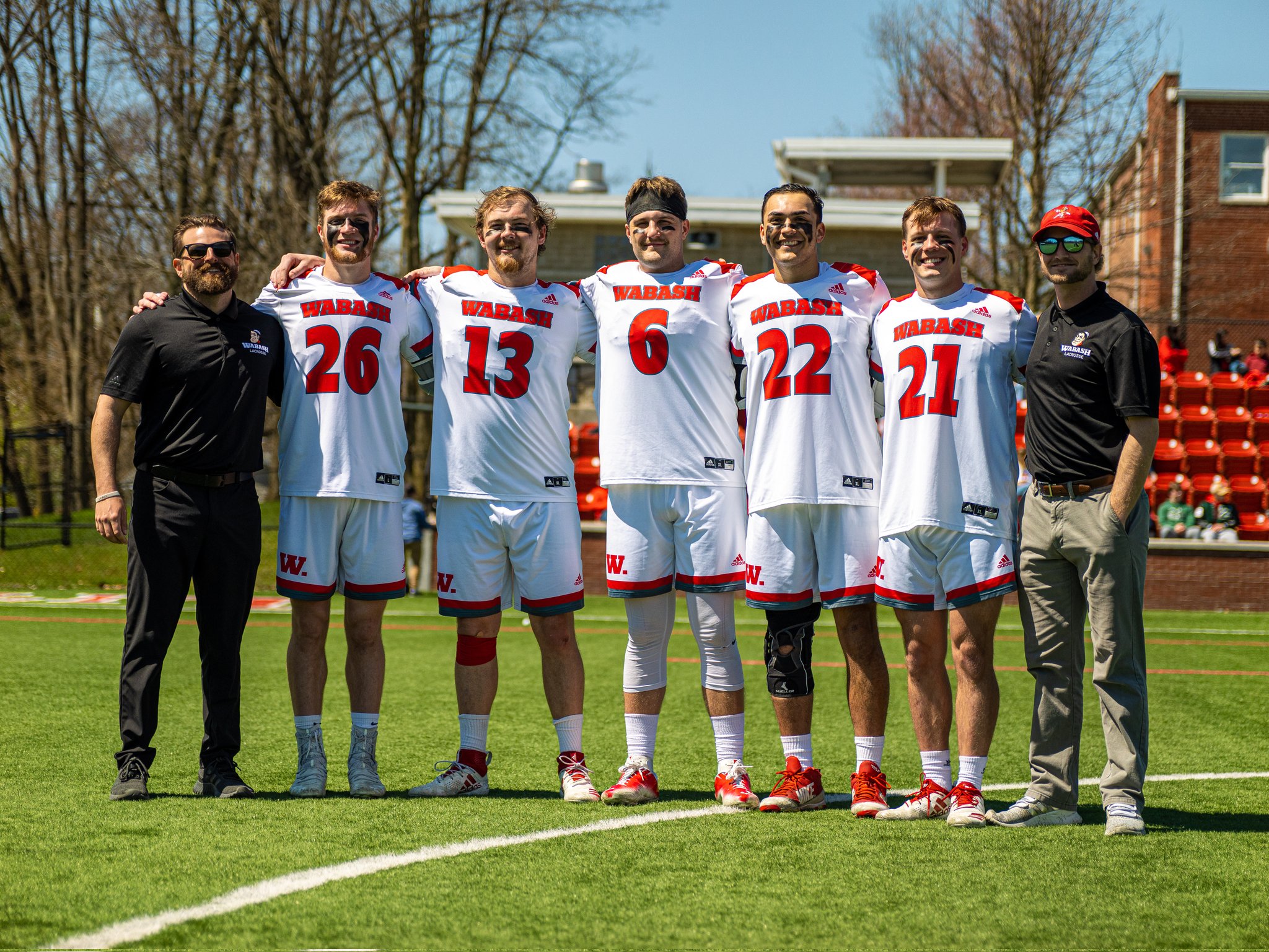 Eaton (third from right) joins Head Lacrosse Coach Chris Burke, Assistant Lacrosse Coach Justin Dionne and other senior student-athletes for a photo before a home game versus Wooster. Eaton has played as a midfielder on the team for the last four years.