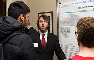 Travis Flock '16 (center) thoughtfully answers a question.