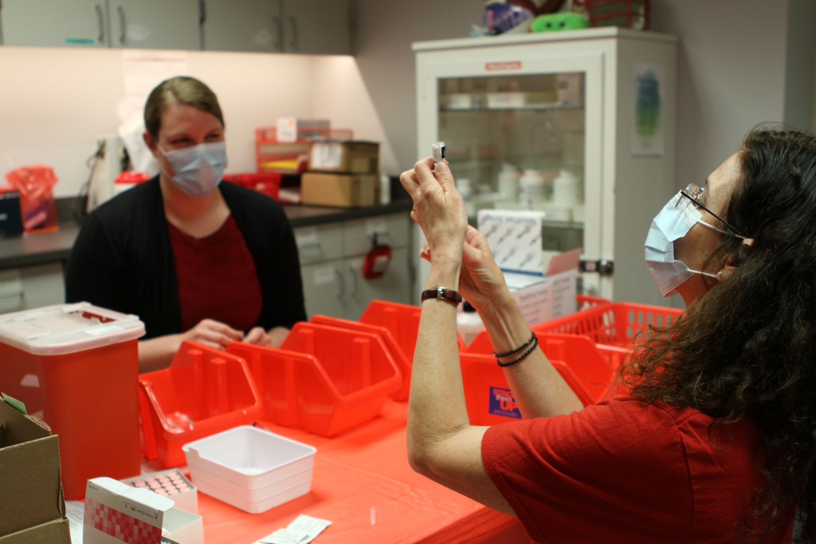 Volunteers Lee Lucas (right) and Tori Gregory prepare vaccines. 