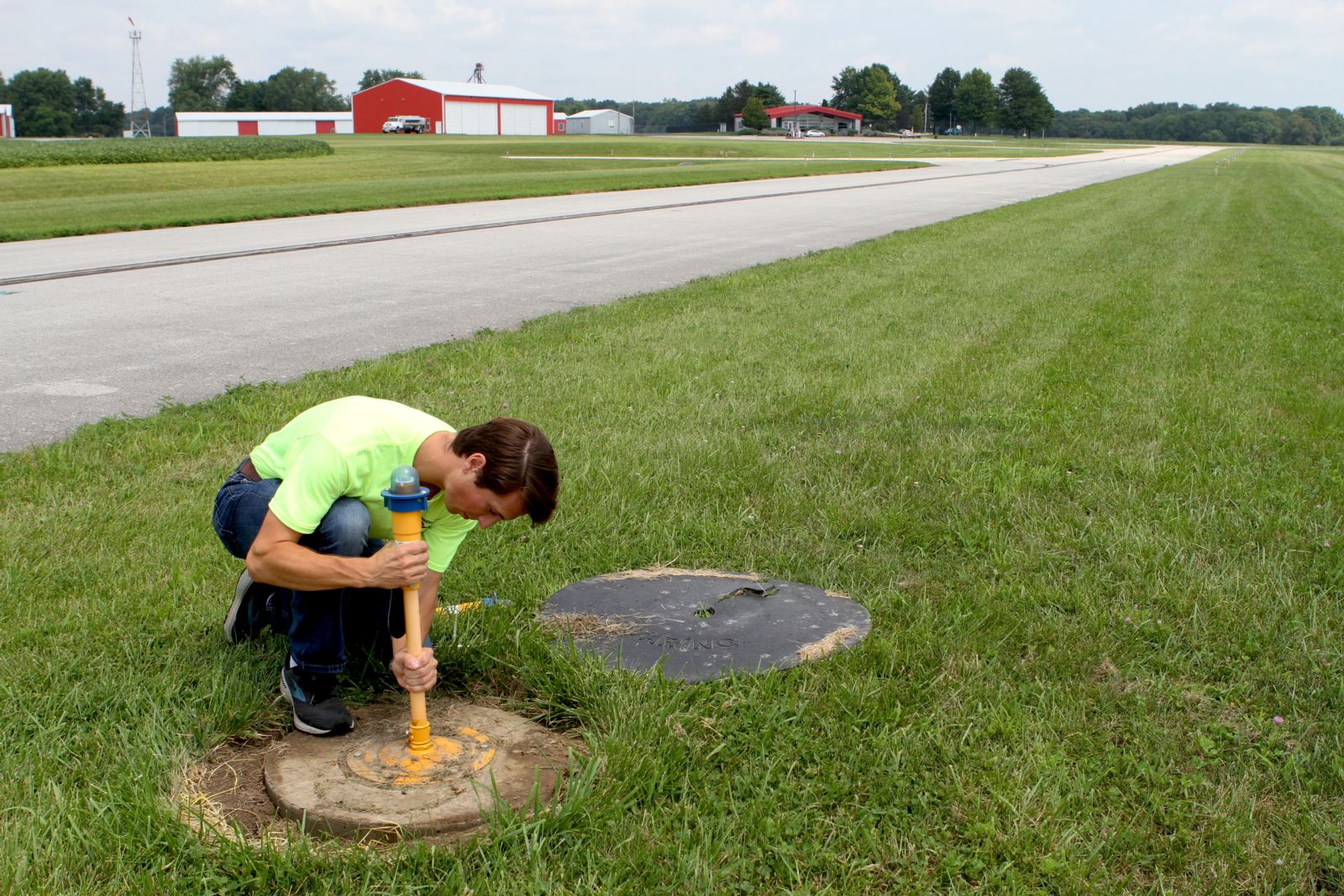 Pine replaces a broken light on the runway. 