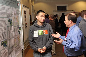Lu Hong '16 discusses his presentation with Dean of the College Scott E. Feller.
