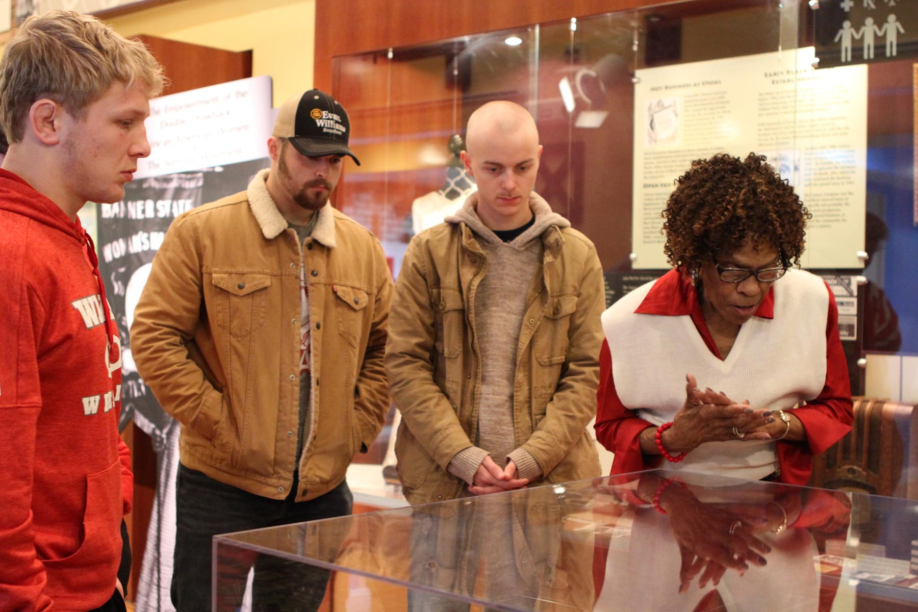 Alex Barr ’22 (far left), Hunter Seidler ’22 and Drew Johannes ’23 learn about local Black history with Janice Hale, Coordinator of Guest Services, at the Evansville African American Museum.	