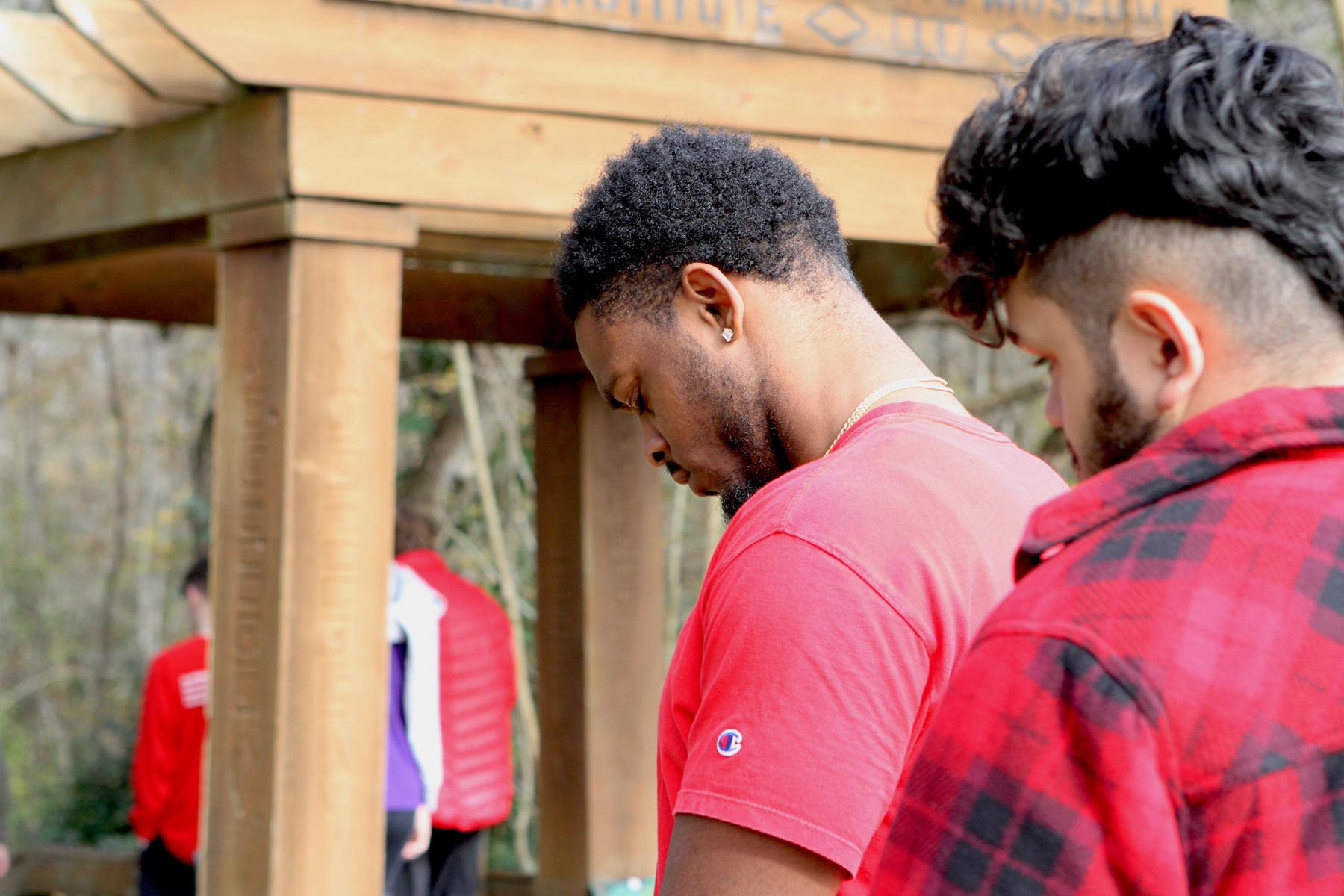 Jamari Washington ’22 (left) takes a moment to say a prayer at a grave marked as the “Tomb of the unknown slave, tomb of the unknown soldier,” located at the Civil Rights Memorial Park in Selma.	