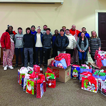 Students, faculty, and staff gathered to wrap gifts in support of the Benchmark Family Services Christmas party.