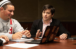 Assistant Professor of Economics Nicholas Snow (right) gives a student feedback on a class assignment.