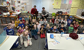 Tyler Watson (rear, left) and Kellen Schreiber visit with students at Laura G. Hose Elementary School.