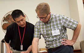 Associate Director Paul Myhre (right) chats with a workshop director.