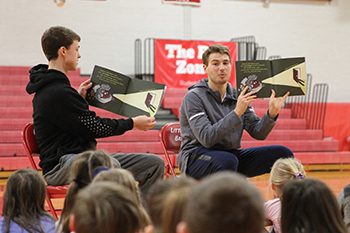 Watson, right, reads to elementary students