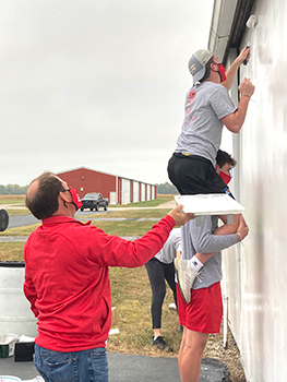 President Feller, left, joins the basketball team in a service project.