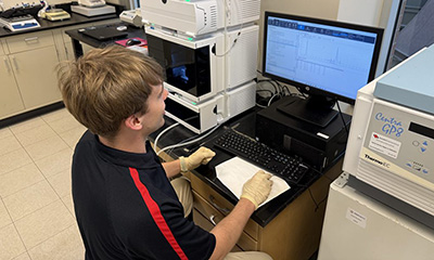 Aidan Pierce ’27 enters lab data in the Perfinity Biosciences lab.