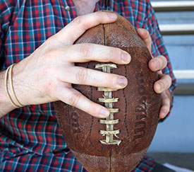 His hands find comfort in an old football.