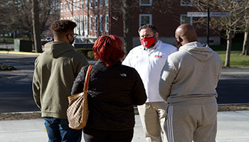 Olmy Olmstead, Assistant Football Coach and Recruiting Coordinator, talks to a prospective student and family during a recent football tour.