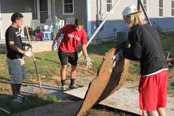 Freshmen load up wood planks at Habitat site.