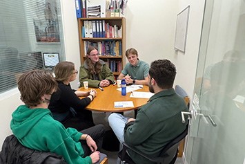 Reynolds and Weilbaker (left and right, facing camera) chat with SASS staff and students at the American College of Greece. 