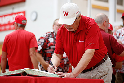 Alumnus signs the alumni register.