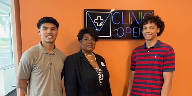 a group of people standing in front of an orange wall
