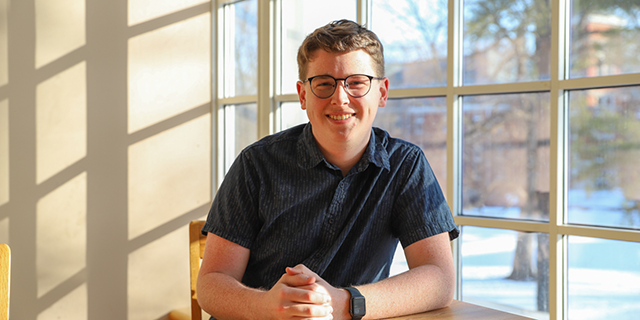 Brady Largent sits at a table in Lilly Library.