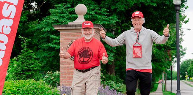 Alumni give thumbs up as they participate in the fun run and walk around campus.