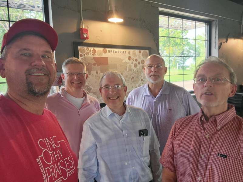 a group of men standing together smiling