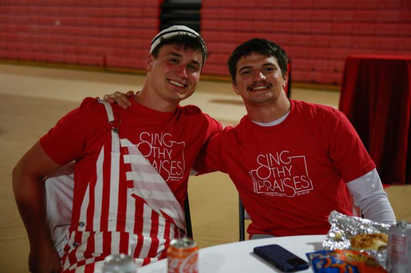 two men wearing matching red shirts