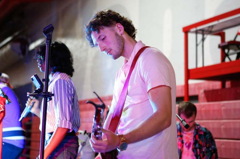 a man playing guitar in front of a group of people