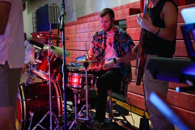 a man playing drums with a guitar and a man playing drums