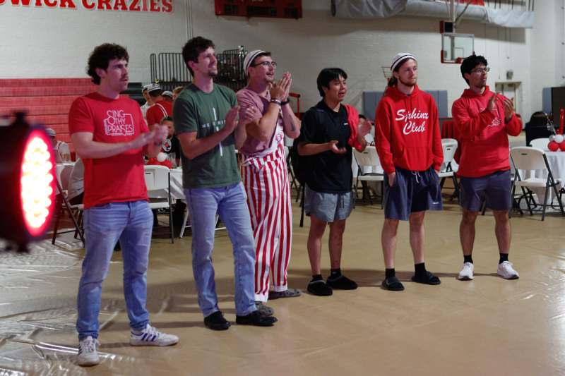 a group of men standing in a room clapping