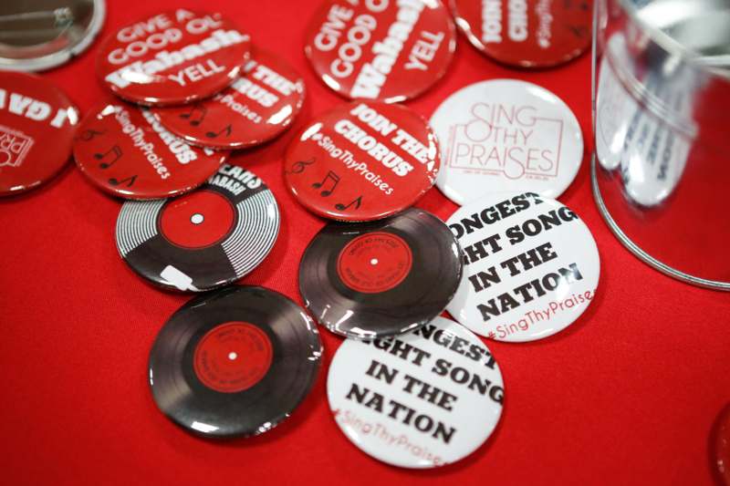 a group of buttons with music notes and a glass of water