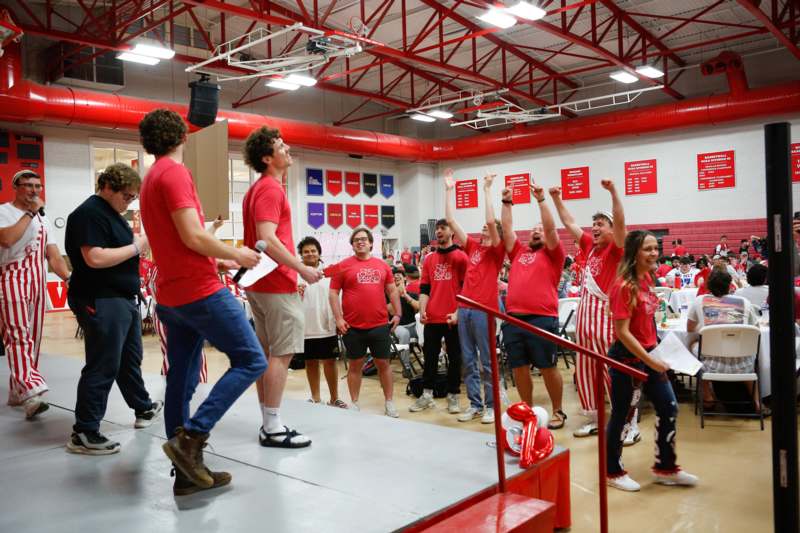 a group of people in a room with red and white shirts