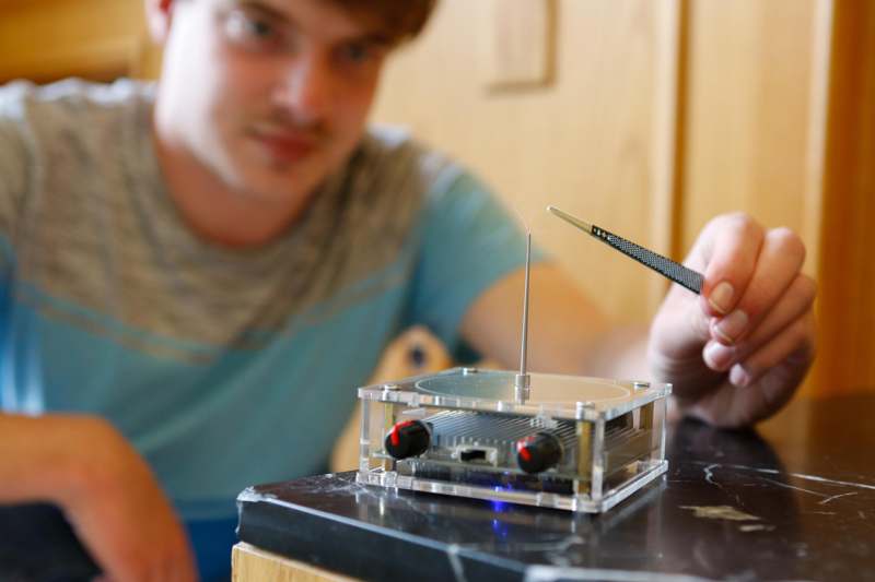 a man holding a tweezers to a device