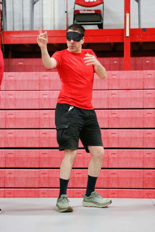 a man wearing a red shirt and black shorts