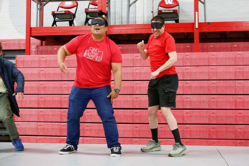 two men wearing red shirts and standing in a stadium