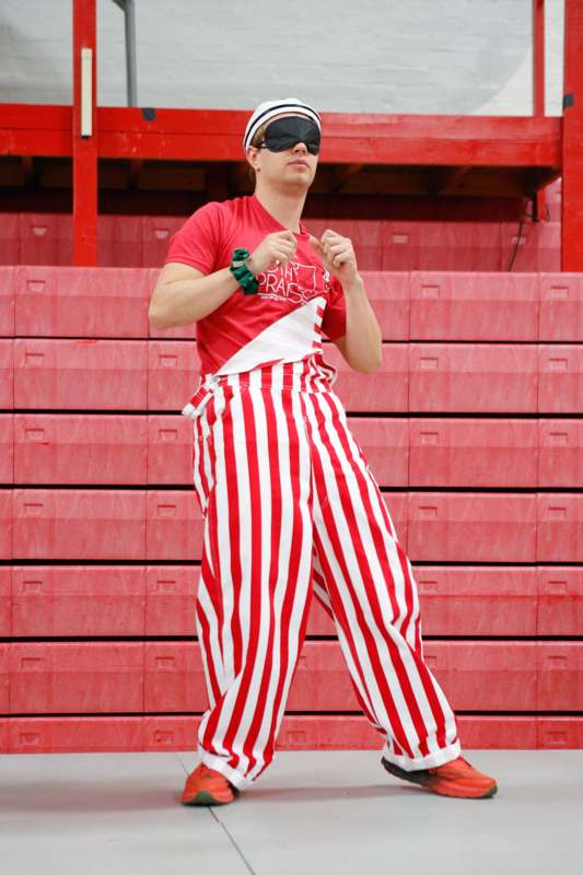 a man wearing a red and white striped pants and a red shirt