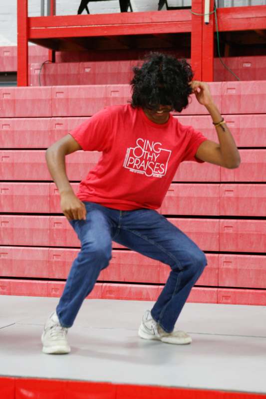 a man wearing a red shirt and blue jeans