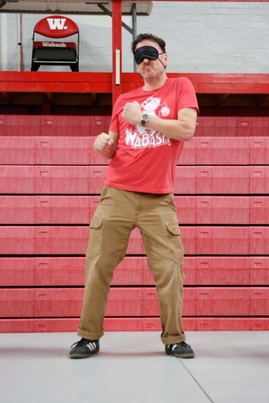 a man standing in front of a red wall