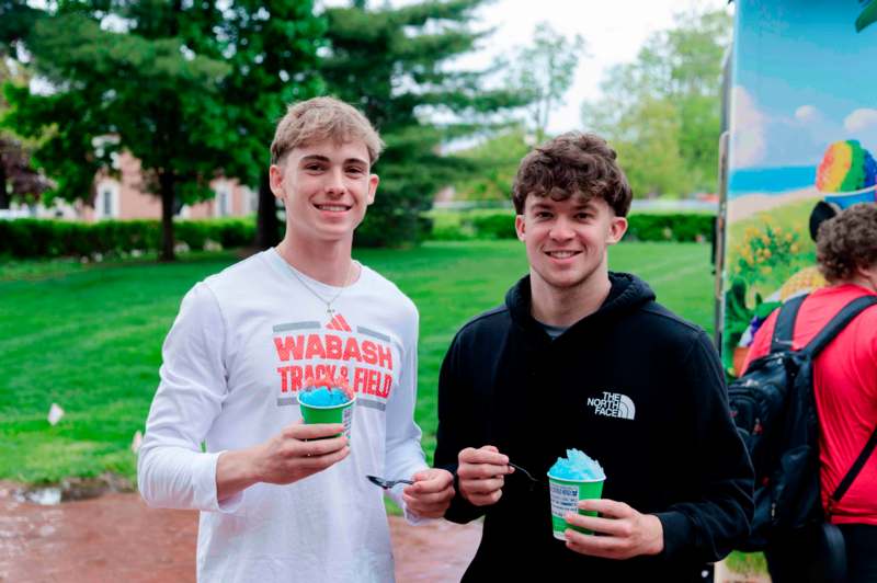 two men holding cups and spoons