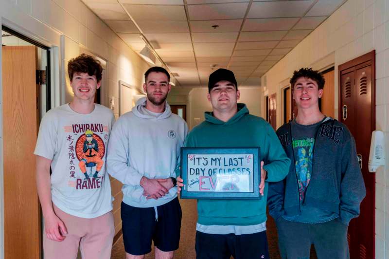 a group of men standing in a hallway holding a sign